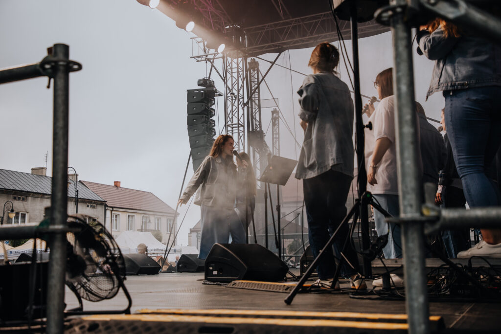Muzycy i wokaliści grający i śpiewający na scenie.